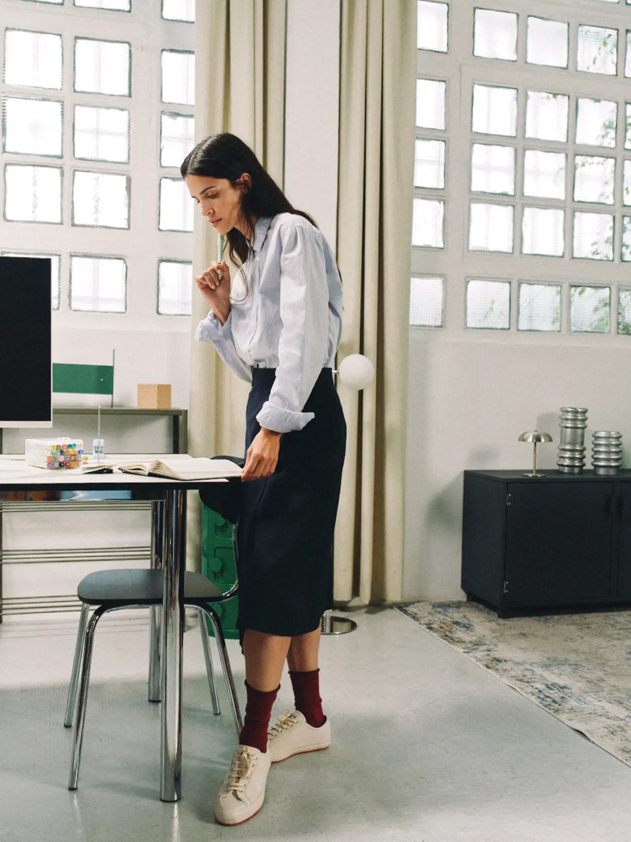 A person standing by a desk in a bright studio