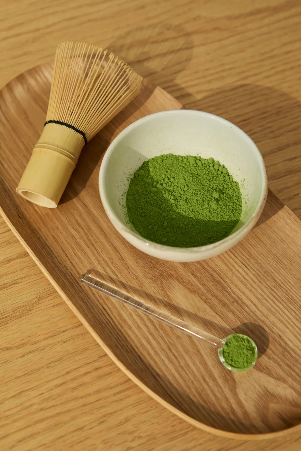 Matcha powder and a whisk on a wooden table